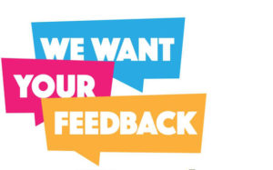 Words "We Want Your Feedback" on blue, pink, and yellow signs