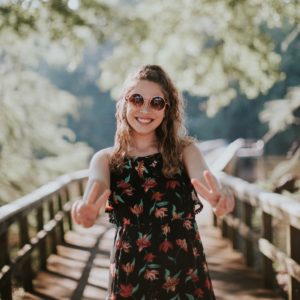 woman on hike smiles on trestle bridge